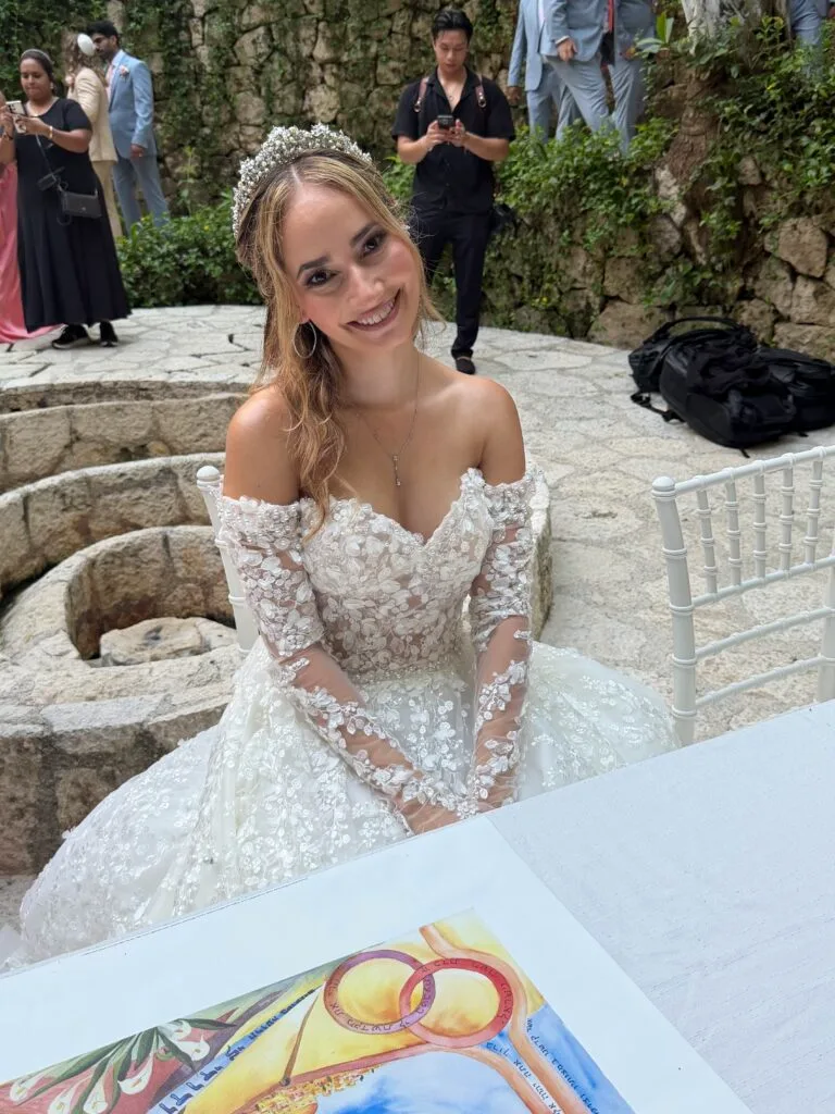 The bride signs her ketubah before her Jewish destination wedding ceremony, a tradition shared on niboca.org