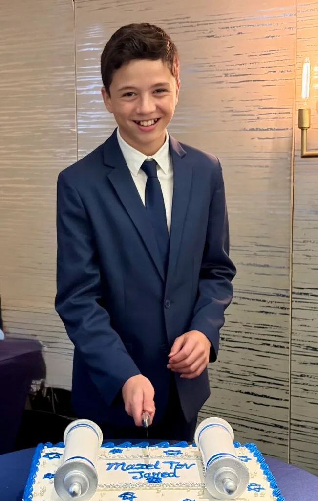 Jared smiling after completing his Bar Mitzvah service, niboca.org"