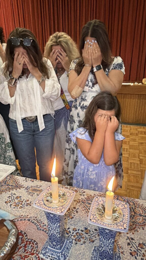 Congregation members lighting Shabbat candles together at Neshamah Institute in Boca Raton